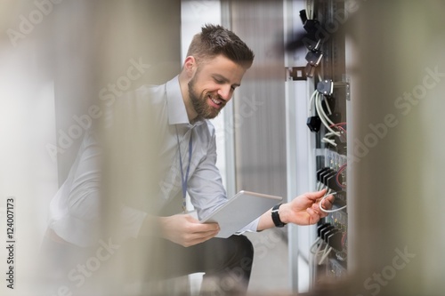 Fotografía Technician using digital tablet while analyzing server