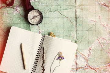 Wall Mural - wanderlust and adventure concept, compass and notebook with wild