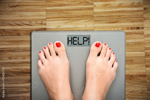 Fotografie, Obraz Time to start a diet with women’s feet on a scale, saying HELP