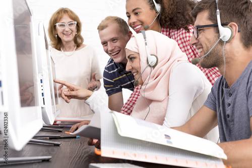 Photo Smiled students looking at the monitor screen