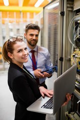 Wall Mural - Technicians using laptop while analyzing server