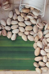 Canvas Print - Pistachio nuts is tasty on wood background.