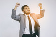 © Tammy54 - Successful young businessman keeping arms raised celebrating his victory on grey background