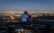 © oneinchpunch - Couple enjoying skyline view from their car