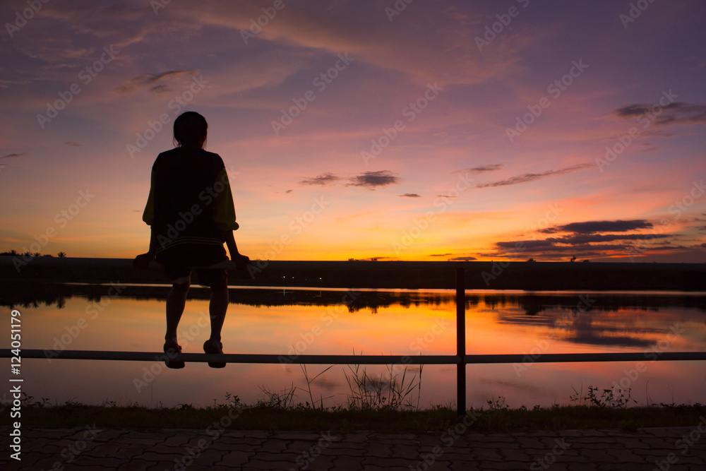 silhouette woman sitting alone on fence look at the sky - obrazy, fototapety, plakaty 