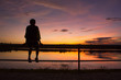 © mckaphoto - silhouette woman sitting alone on fence look at the sky
