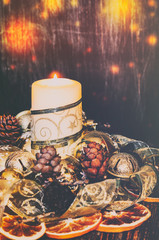 Wall Mural - Christmas home decoration.Candles, ornaments .Dried oranges, Golden ribbon, fir cones on a wooden browm background. Lighting effect