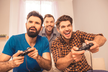 Canvas Print - Close up portrait of excited happy cheerful men play video game