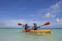 Two Women In Lifejackets Paddling In A Yellow Boat; Punta Cana, La Altagracia, Dominican Republic
