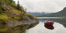 A Red Rowboat Moored In Bjorna Fjord; Hardangervidda, Norway