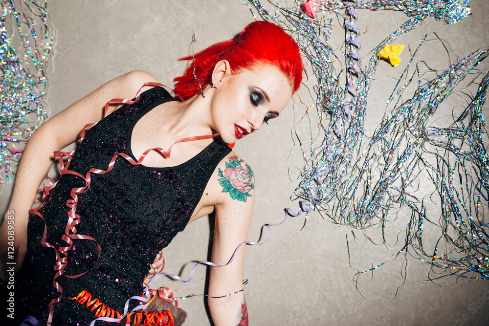 Drunk redhead college girl lying on the road in garbage. Young woman abuse at new year party. Partying and getting drunk.