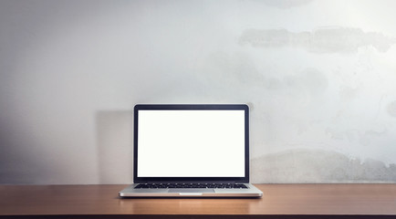 Front view of the laptop is on the work table, concrete backgrou