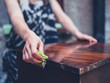 © LoloStock - Young woman cleaning old furniture