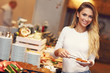 © Kalim - Attractive woman at breakfast buffet in hotel