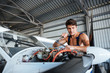 © Drobot Dean - Serious young aircraft mechanic fixing small airplane