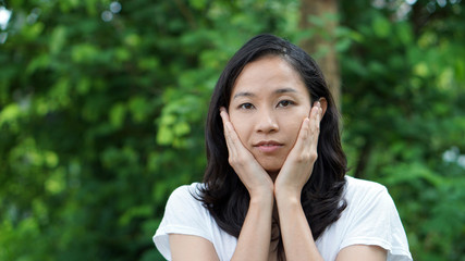 Wall Mural - South East Asian girl looking at camera green background