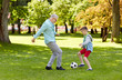 © Syda Productions - old man and boy playing football at summer park