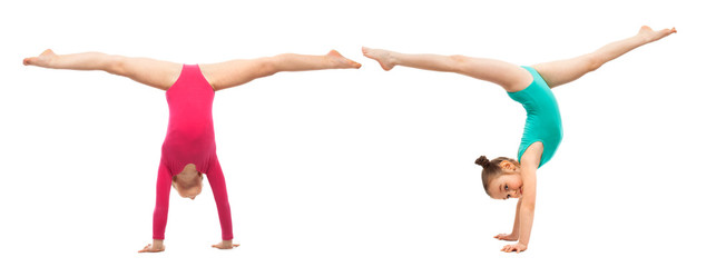 Flexible kids gymnasts standing on hands, isolated white background