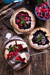 Blueberry,cherry,raspberry and blackcurrant galette on w wooden background.