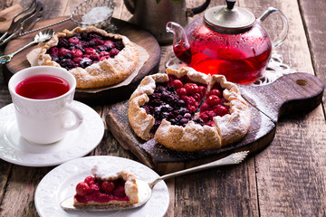 Blueberry,cherry,raspberry and blackcurrant galette on w wooden background.