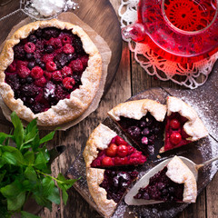 Blueberry,cherry,raspberry and blackcurrant galette on w wooden background.