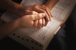 © Designpics - Holding Hands And Praying Over The Bible