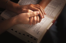 Holding Hands And Praying Over The Bible