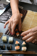 Woman Preparing Sushi Rolls At Home