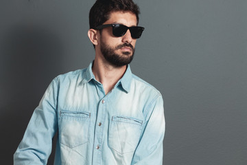 Wall Mural - Young hipster bearded man with sunglasses - gray background