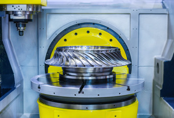 High-precision CNC machine processes steel turbine wheel.