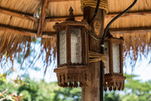 Two Lantern Tied With Rope To The Wooden Pole Under The Pavilion In A Daylight.