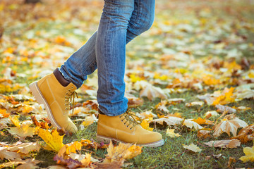 Warm yellow boots. Walking in autumn leaves