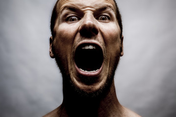 close up portrait of a man shouting, mouth wide open