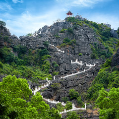 Wall Mural - Stairway at limestone mountain to Hang Mua view point. Popular tourist attraction at Tam Coc, Ninh Binh. Vietnam travel landscapes and destinations