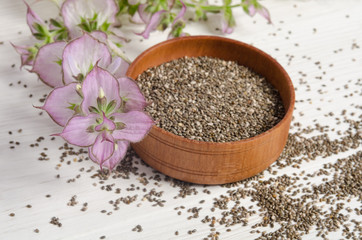 Chia seed healthy super food with flower over white wood backgro