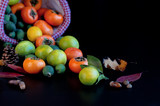 Fototapeta Kuchnia - Фрукты в корзине: хурма, лимоны, фейхоа с осенними листьями