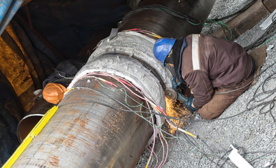 Trimming of the weld by mechanical means. Two locksmith carry out simultaneous machining of the weld with different sides