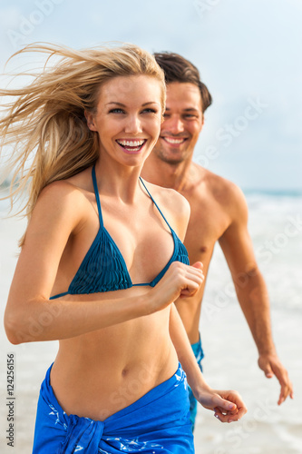 Zdjęcie XXL Młoda para mężczyzna i kobieta gra w Surf na plaży