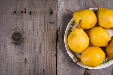 Fresh ripe organic yello pears on rustic wooden table, natural background, diet food.