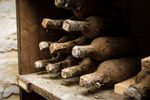 Lying Dusty Old Bottles Of Wine In The Italian Vineyard.