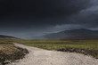 © Designpics - A gravel path under dark storm clouds;Highlands scotland