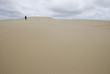 © Designpics - A woman walking alone on a sand dune in the distance;Florence oregon united states of america