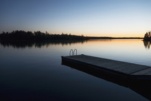 Sunset Over A Lake With A Wooden Dock;Lake Of The Woods Ontario Canada