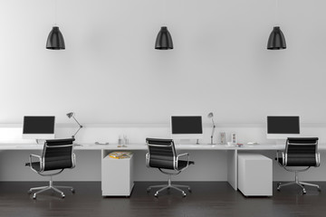 Work desks in empty room with big wall in background