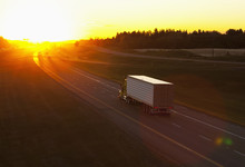 Truck Heading Down A Highway At Sunset; Edmonton, Alberta, Canada