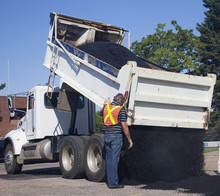 Workman Dumping Asphalt For Pothole Repairs; Edmonton, Alberta, Canada