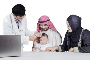 Wall Mural - Doctor check the fever of Arabian baby