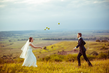 Wall Mural - Apples fly over the wedding couple playing on the field