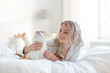 © Syda Productions - happy young woman with cat in bed at home