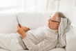 © Syda Productions - senior man with tablet pc lying on sofa at home
